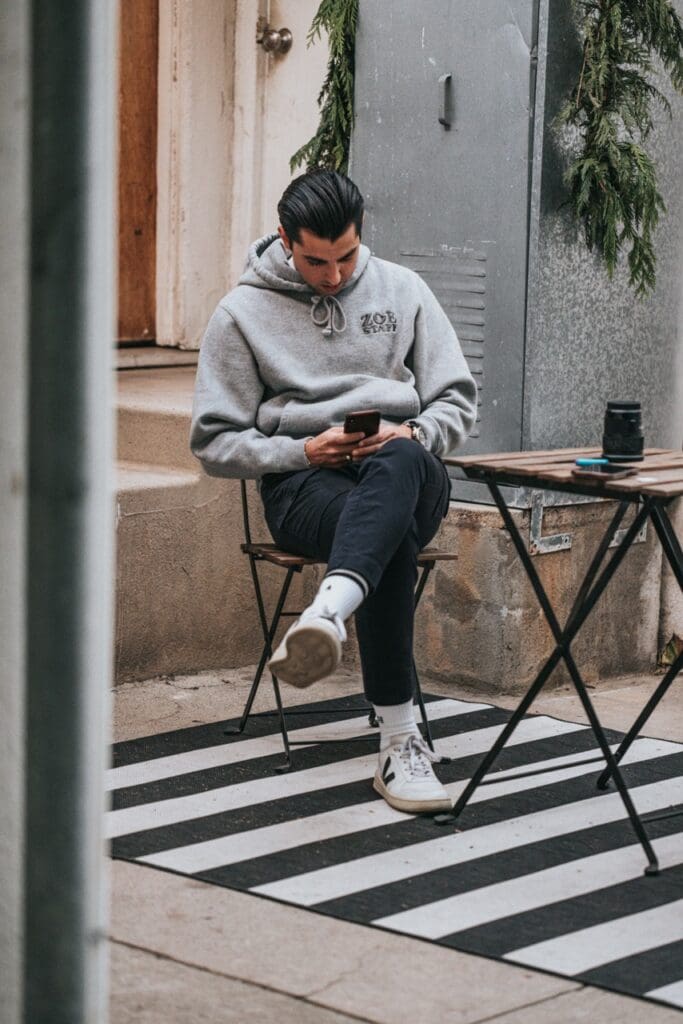 Small business owner sitting at a cafe and deciding what to post on his social media 