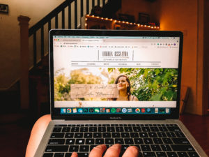 Image of Lauren Osselton Homepage displayed on MacBook with twinkle lights in background