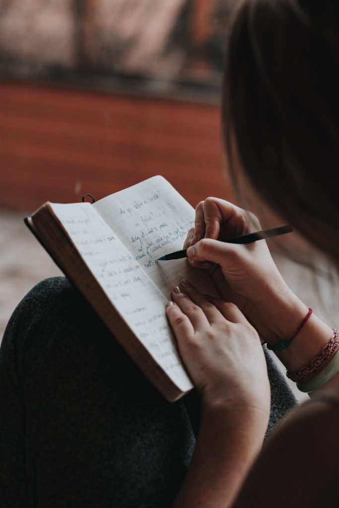 Woman writing down motivational quotes to inspire 