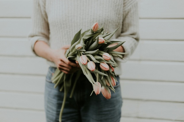 woman practicing emotional intelligence by giving a grieving friend or colleague some flowers 