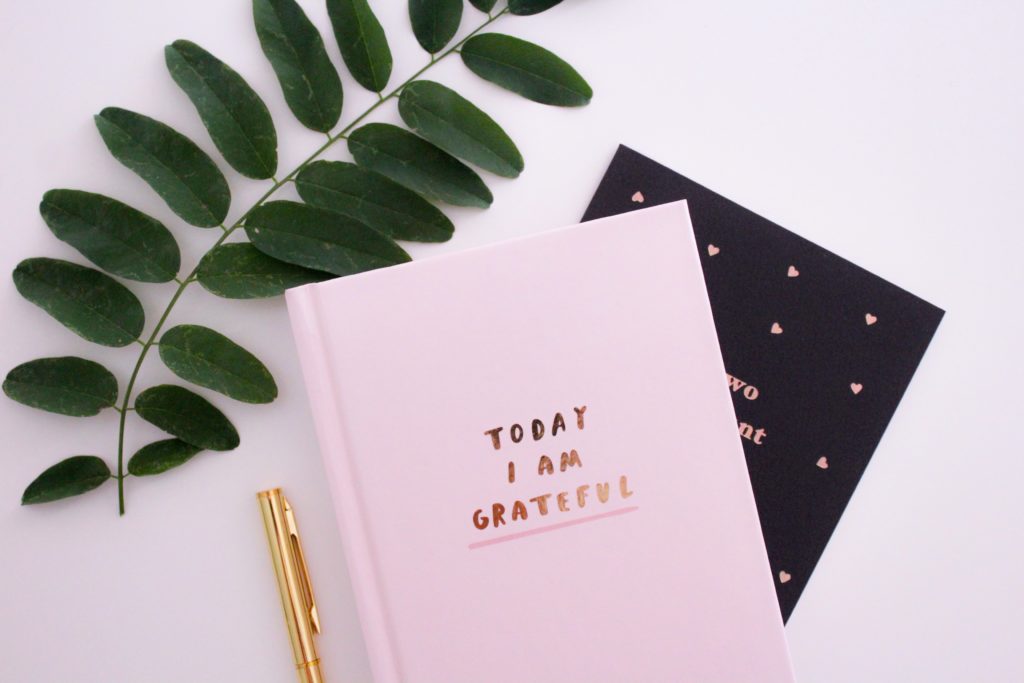 Gratitude journal for a gratitude list lies open on a table 