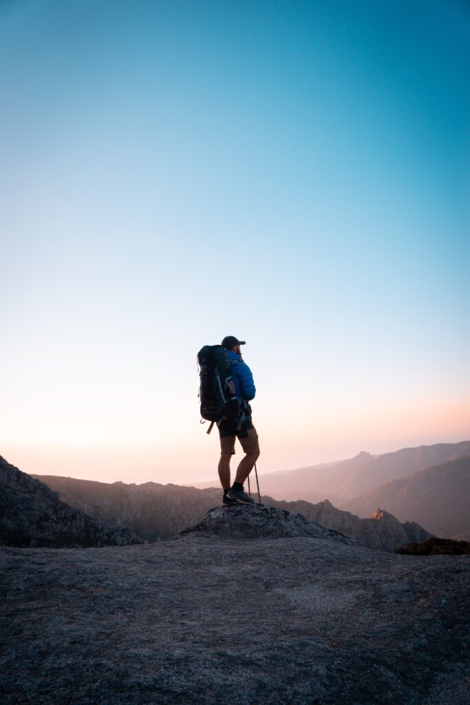 Man communes and connect with nature by pausing for a meditative moment during a hike 