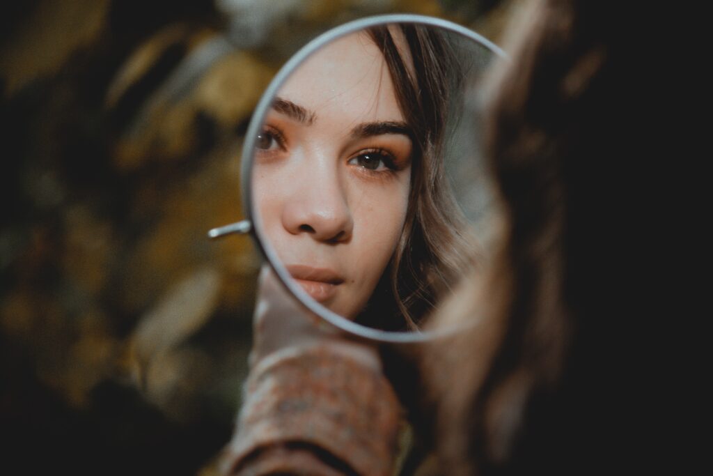 Woman looking in a mirror to practice affirmations 