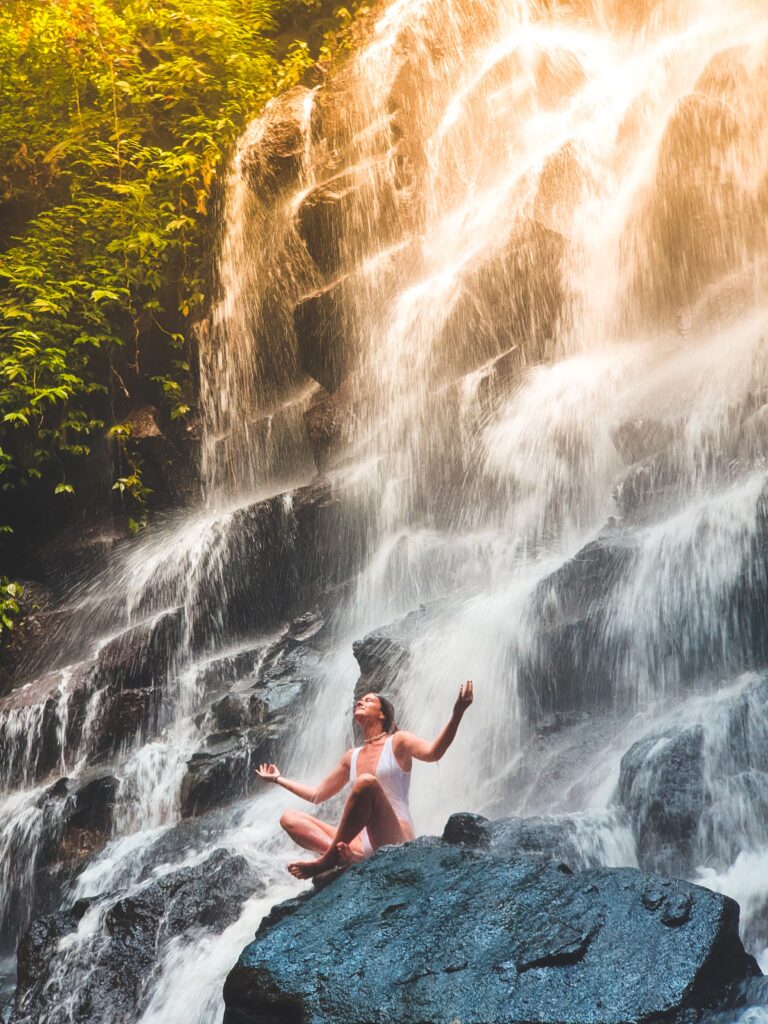 Woman takes inventory of her mind, body and soul by meditating in a waterfall 