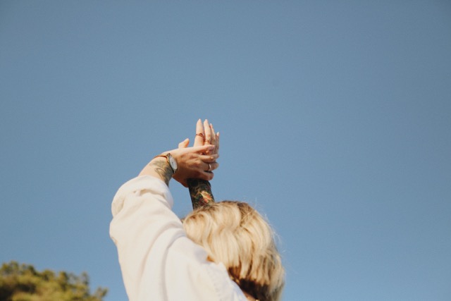 Woman holding her arms in the air, feeling in flow embodying her design 