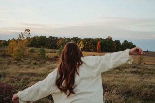 Woman running through a field feeling free and self-aware 