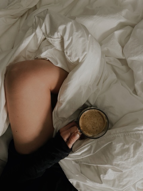 Woman resting in bed, recovering from burnout 